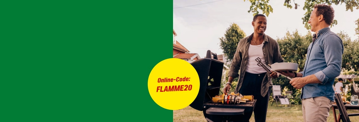 Zwei lachende Personen grillen mit einer Grillzange im Garten.